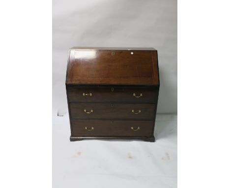 A GEORGIAN MAHOGANY SLOPE FRONT BUREAU with three long graduated drawers on bracket feet  115cm x 107cm x 54cm