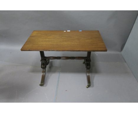 A REGENCY STYLE OCCASIONAL TABLE the rectangular top with reeded rim raised on column supports with splayed legs brass toes a
