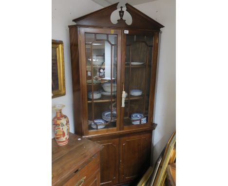 A MAHOGANY DOUBLE DOOR CORNER CABINET with architectural pendant above astragal glazed doors and cupboards on bracket feet  1