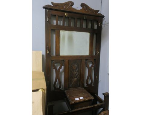 AN OAK FRAMED HALL STAND the rectangular back with bevelled plate and foliate carved panel the open base fitted with a single