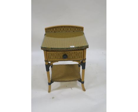 A MODERN CANE GLASS MOUNTED SIDE TABLE with raised gallery single frieze drawer above an open shelf on splayed supports  70cm