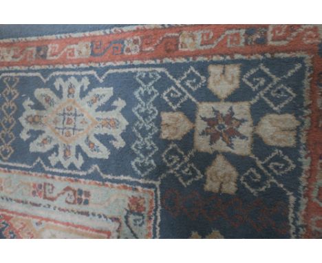 A WOOL RUG the light blue pink and beige ground with central panel within a conforming border 231cm x 168cm 