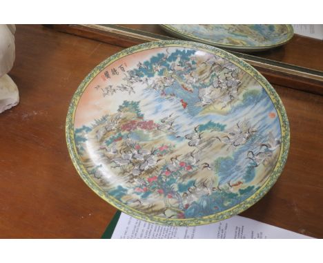 A PAIR OF ORIENTAL PLATES each with a light pink and blue ground and exotic birds amongst flower heads and foliage  34cm diam