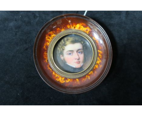 A GEORGIAN STYLE OVAL FRAMED PORTRAIT OF A YOUNG BOY in a faux tortoise shell frame