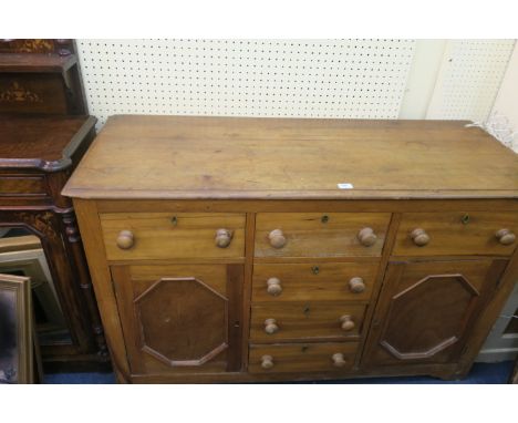AN OAK CHEST OF DRAWERS the rectangular top with molded rim above an arrangement of short drawers with two cupboard doors on 