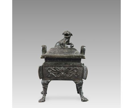 the black bronze vessel of rectangular section with lion finial cover, the sides with taotie in low relief on a leiwen field,