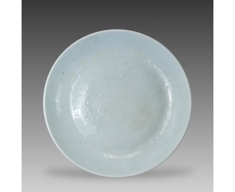 well incised, beneath a glaze of bluish tone, with a central lotus flower and scroll medallion within a wave border, the roun