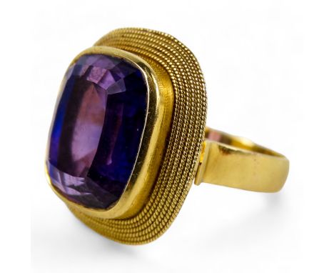 An 18ct gold amethyst dress ring - the cushion cut stone set within a rope-twist band, size N/O, 8.9g