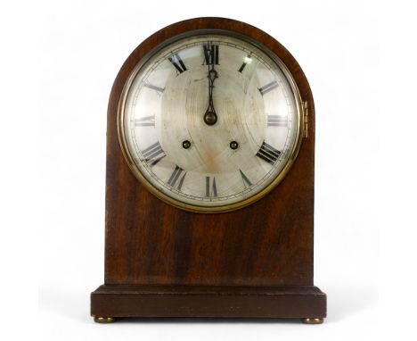 An early 20th century mahogany mantel clock - the domed case raised on brass bun feet, with a silvered dial set out with Roma