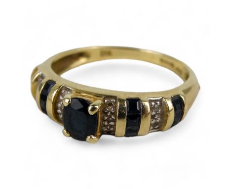 A 14ct gold sapphire and diamond dress ring - with oval cut central stone, size K, 2.6g