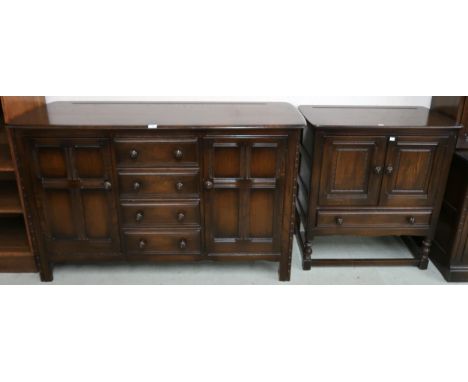 A 20th century Ercol stained elm and beech sideboard with three central drawers flanked by panel cabinet doors, 90cm high x 1