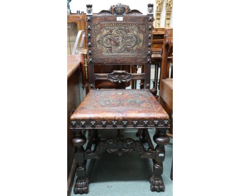 A Victorian stained oak framed Baronial style hall chair with leather back and seat embossed with armorial helmet over styliz