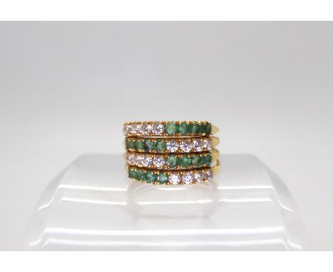 An 18k gold emerald and clear gem four part ring, finger size Q, weight 5.4gms Condition Report:Available upon request