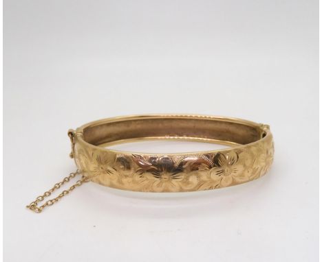 A 9ct gold flower engraved bangle, inner diameter 6.5cm, weight 17.6gms Condition Report:Available upon request