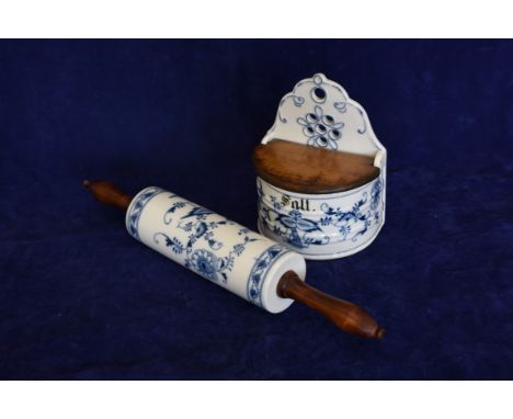 A blue and white porcelain wall hanging salt holder with pierced back section and hinged wooden lid above a stylised leaf dec