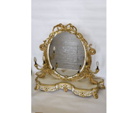 A white painted and gilt dressing table mirror with ribbon form surmounts above the oval mirror plate and with three candle b