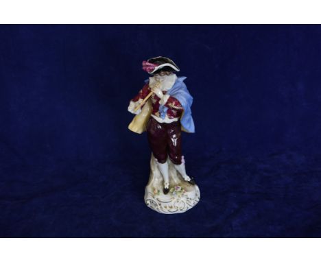 A Sitzendorf porcelain figure of a young boy wearing a tricorn hat and playing a flute type instrument while wearing a blue c