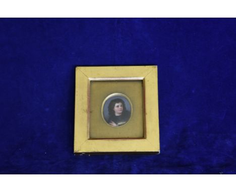 An oval portrait miniature of a young boy with wavy brown hair. In a gilt mount and gilt frame. 1¾ by 2ins. Est £30-50