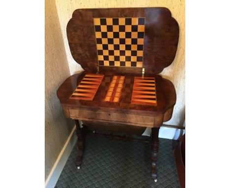 A Victorian walnut and boxwood marquetry inlaid sewing table/games table.  The fold-over lid opening to reveal a chessboard, 