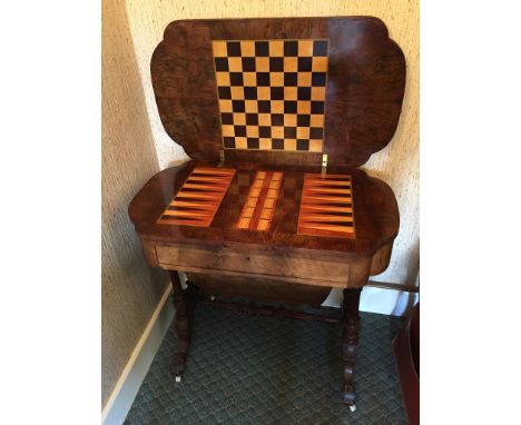 A Victorian walnut and boxwood marquetry inlaid sewing table/games table.  The fold-over lid opening to reveal a chessboard, 