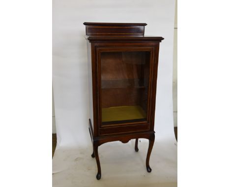 An Edwardian display cabinet with raised upstand, ebony and boxwood stringing and single glazed door revealing a glass shelf 