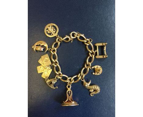 A 9ct gold charm bracelet set with eight charms to include Tower Bridge, a horseshoe with fox mask centre, a seahorse, a fob 