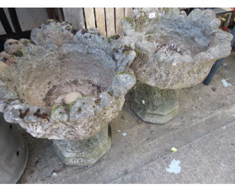 PAIR OF COMPOSITE STONE GARDEN URNS ON PLINTHS