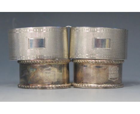 A pair of George V silver napkin rings, maker H F Withers, Birmingham, 1920, with engine turned decoration, together with ano