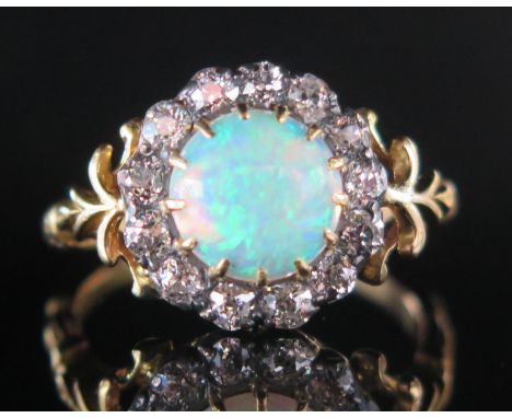 An 18ct Gold, Opal and Diamond Cluster Ring, c. 8.2mm principal singlet specimen surrounded by c, 2.2mm old cuts, 12.8mm head