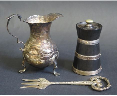 A George III silver cream jug, unknown maker, London, possibly 1769, crested, of baluster form with acanthus capped scroll ha