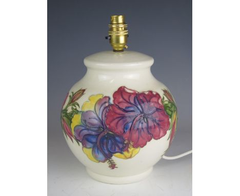 A Moorcroft pottery table lamp of globular form with Hibiscus decoration to an ivory ground, overall height 29cm. 