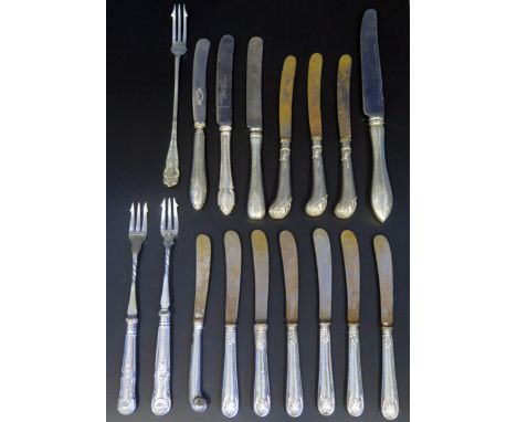 A collection of silver handled butter knives, table knives, and pickle forks. 