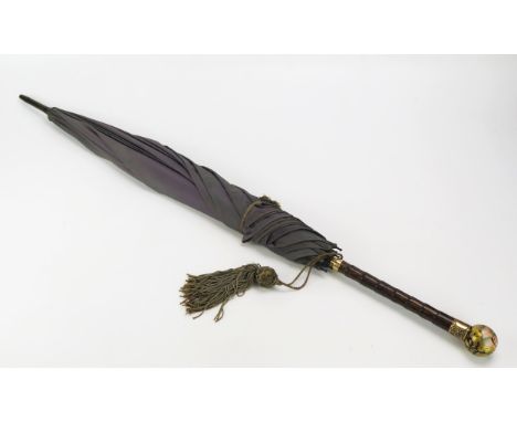 A good quality Victorian parasol, with pale purple canopy, having a gilt metal mounted faux zebra wood handle, the porcelain 