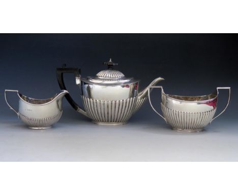 A matched three-piece tea service, various makers and dates, of oval outline with half reeded decoration, total weight of sil