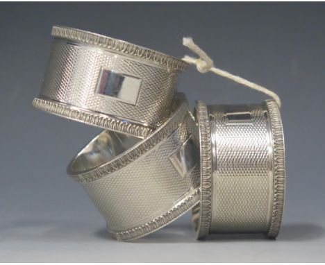 A set of three George V silver napkin rings, maker H F Withers, Birmingham, 1920, with engine turned decoration, total weight