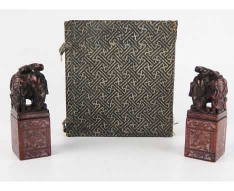 A pair of Chinese carved hardstone seal, of rectangular outline surmounted with figures and an elephant, 10.5cmm high, cased.