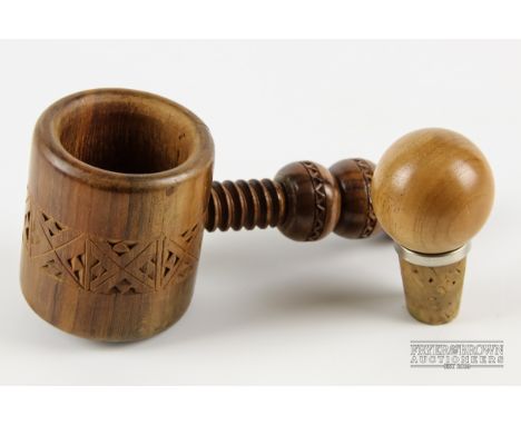 A treen nutcracker with carved decoration; and a turned wood and cork bottle stopper (2)
