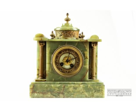 An onyx mantel clock, the white enamel dial flanked by brass pillars, Roman numerals