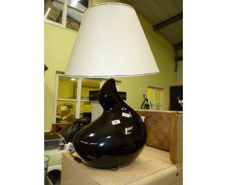 A black stylised table lamp with a cream shade.