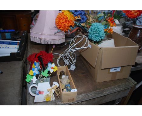 A quantity of artificial flowers and table lamps.