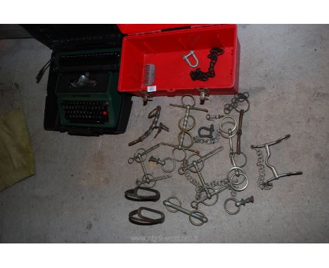 A box of stirrups and driving bits, a boxed portable typewriter.
