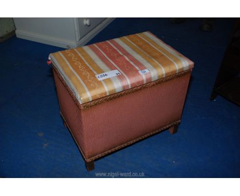 A Lloyd Loom style rectangular laundry box with seat.