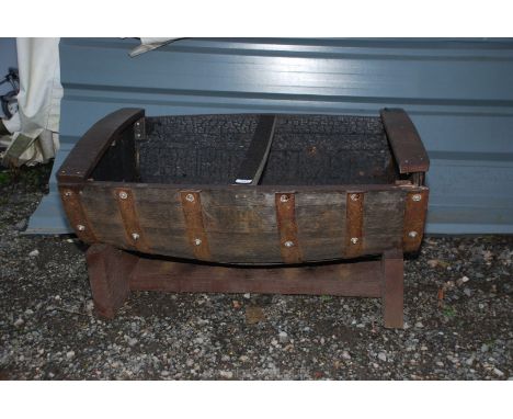 A garden planter made from an old whisky barrel.