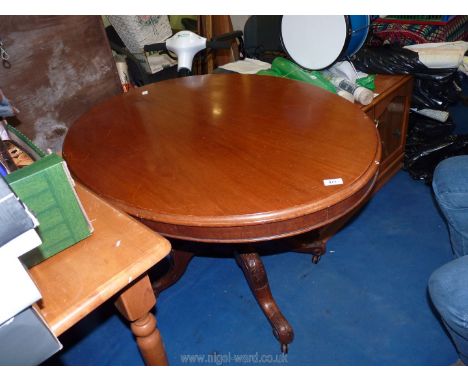 An oval occasional table with a carved pedestal base. 47" x 33" x 30"