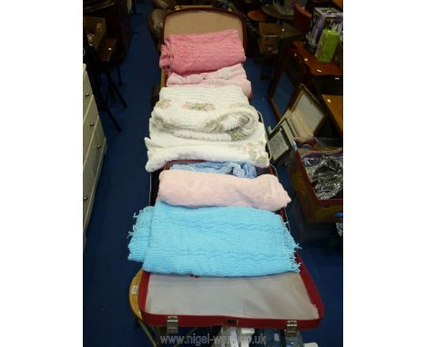 Three suitcases full of vintage bed spreads.
