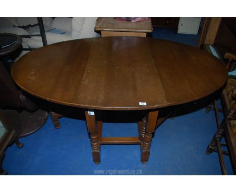 A round ended drop-leaf gateleg dining table on turned legs, 65" x 41" 29" h open.