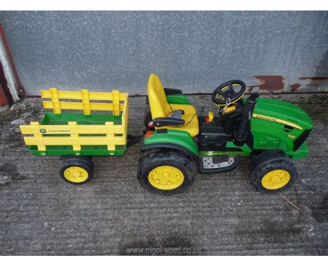 A battery operated John Deere child's tractor and trailer, in working order.