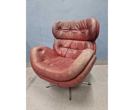 A red leather swivel chair, the curved button upholstered back and seat on a column and four bar legs