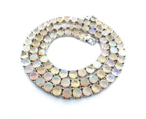 An Ethiopian opal set silver Riviere necklace. Each opal is approximately 5.1 mm. The line necklace length is 46 cm. Weight 3