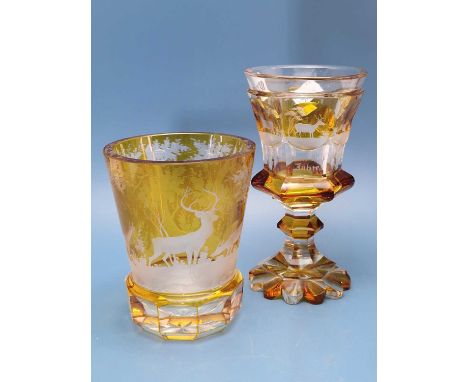 A Bohemian amber overlay glass goblet, the bowl engraved with stag hunting ovals above an inscription and the date 1873.   H 
